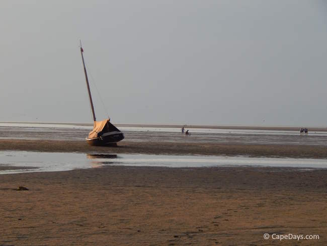 Breakwater Beach in Brewster at low tide, with a sailboat high-and-dry on the tidal flats at sunset