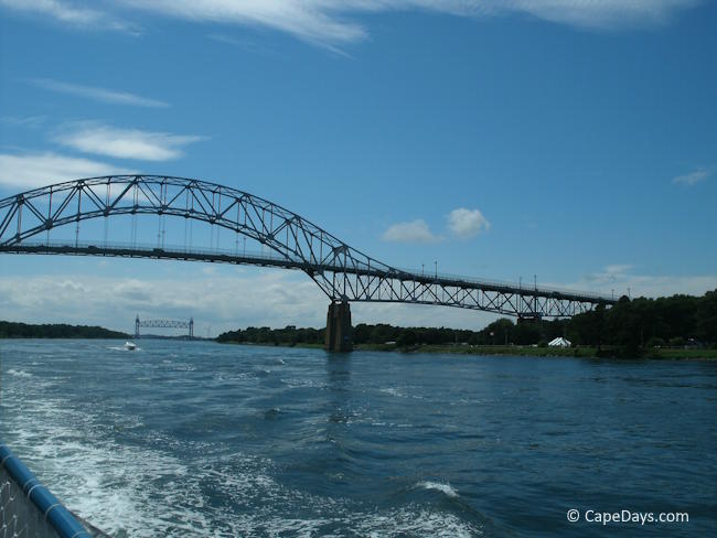 View from a Cape Cod Canal cruise boat approaching the Bourne Bridge with the Railroad Bridge in the distance