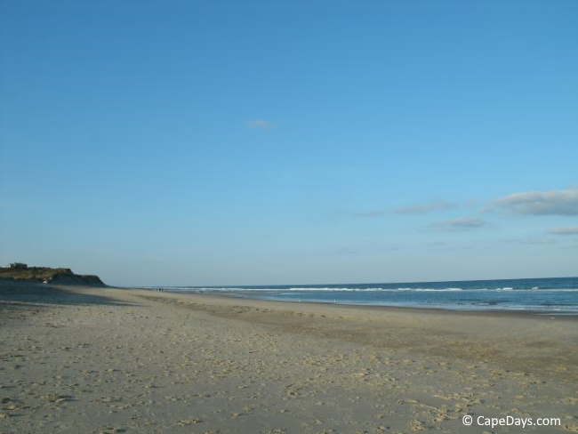 Deserted beach, tall dunes, and ocean waves Deserted beach, tall dunes, and ocean waves