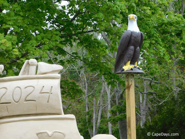 Eagle statue sitting on a pole by the large sand sculpture at the Rt. 28 Visitors Center in Yarmouth.