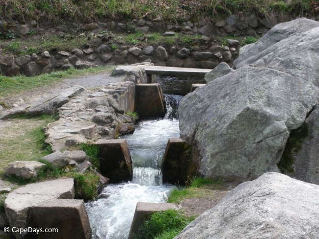Water flowing over narrow waterfalls, boulders lining the brook Water flowing over narrow waterfalls, boulders lining the brook