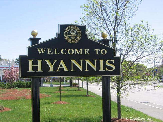 Dark brown sign with gold lettering saying "Welcome to Hyannis"