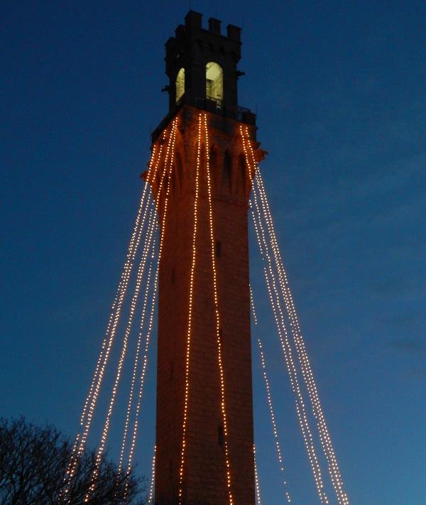 Tall, granite monument strung with hundreds of white lights for the Holidays