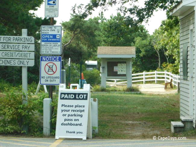 Signs at a Massachusetts state park beach explaining how to pay for parking and where to place your pass