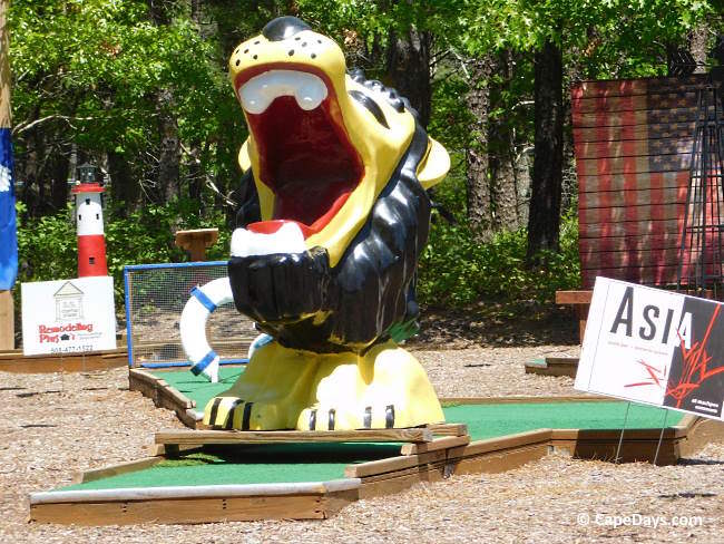 Large roaring lion statue over putting green at Mashpee Mini Golf