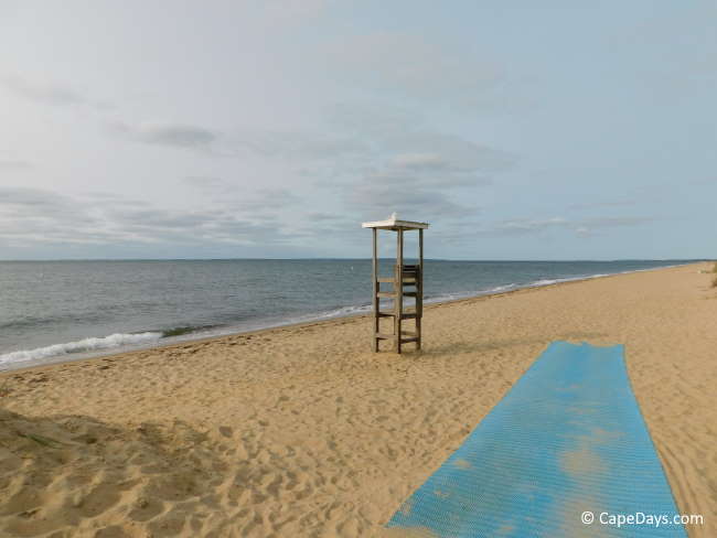 Blue "Mobi-mat" across the sand leading to the beach, lifeguard stand facing out toward a calm, open ocean