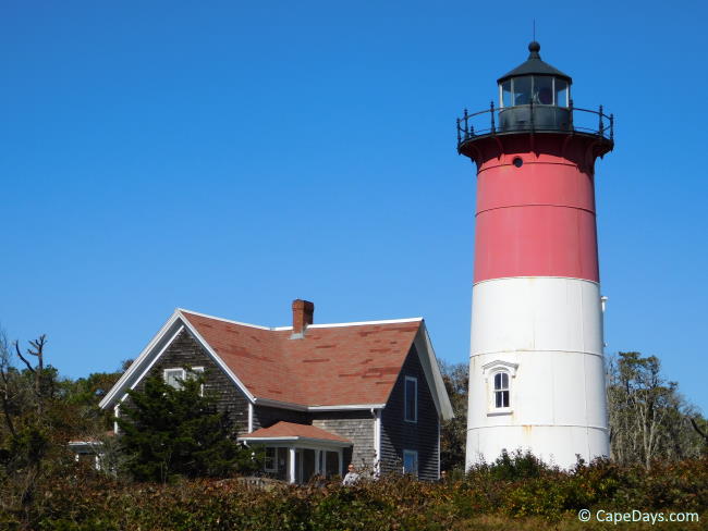 Close-up of Nauset Lighthouse and the keeper’s house under a bright blue sky