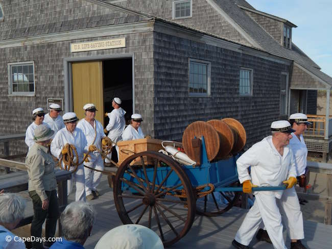 Rescue drill reenactment at Old Harbor Life Saving Station with surfmen hauling equipment