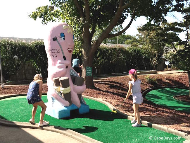 Children playing mini golf near Princess Tina the pink octopus at Putters Paradise on Cape Cod