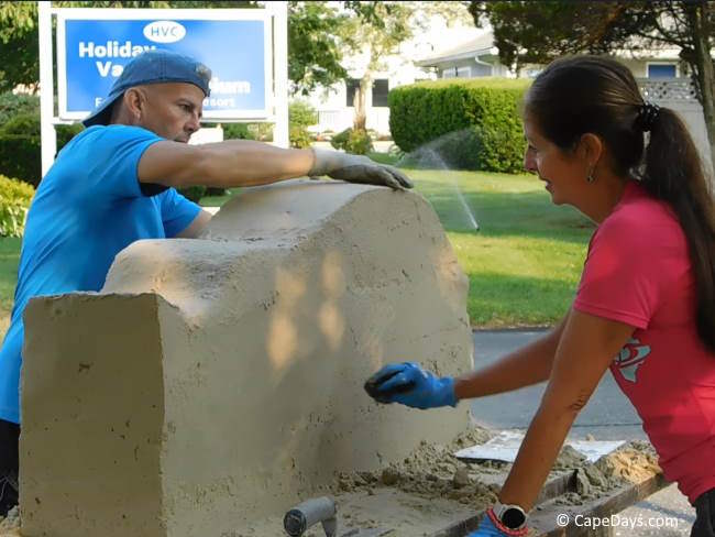 Sculptors working on a sand sculpture in West Yarmouth