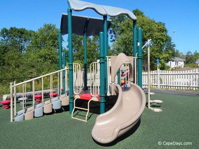 Accessible play structure at Luke’s Love Boundless Playground in Barnstable, with colorful stairs, grab rails, and an attached slide Accessible play structure at Luke’s Love Boundless Playground in Barnstable, with colorful stairs, grab rails, and an attached slide
