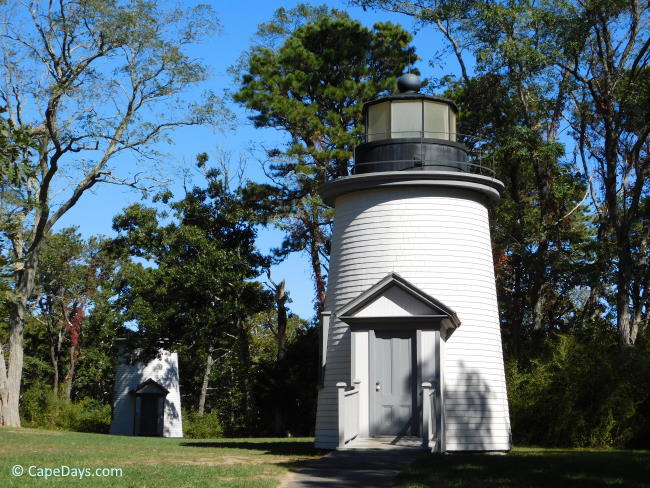 Small, white lighthouses set in a wooded area