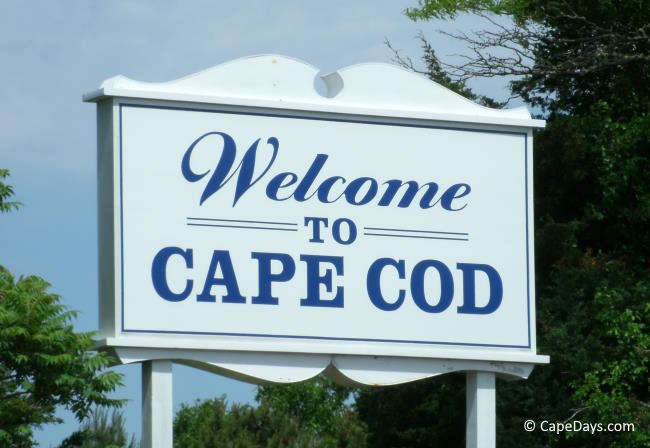 White sign with blue letters saying "Welcome to Cape Cod"